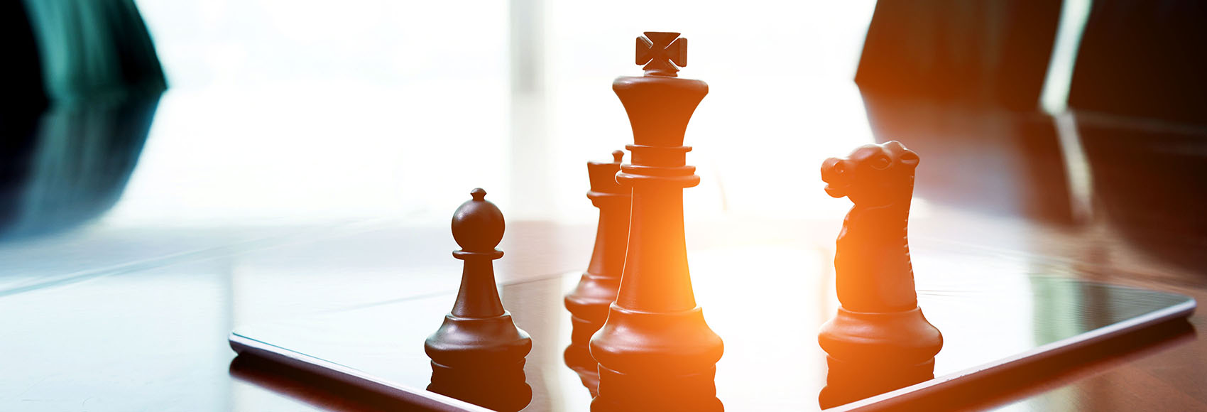 Chess pieces standing on a digital tablet