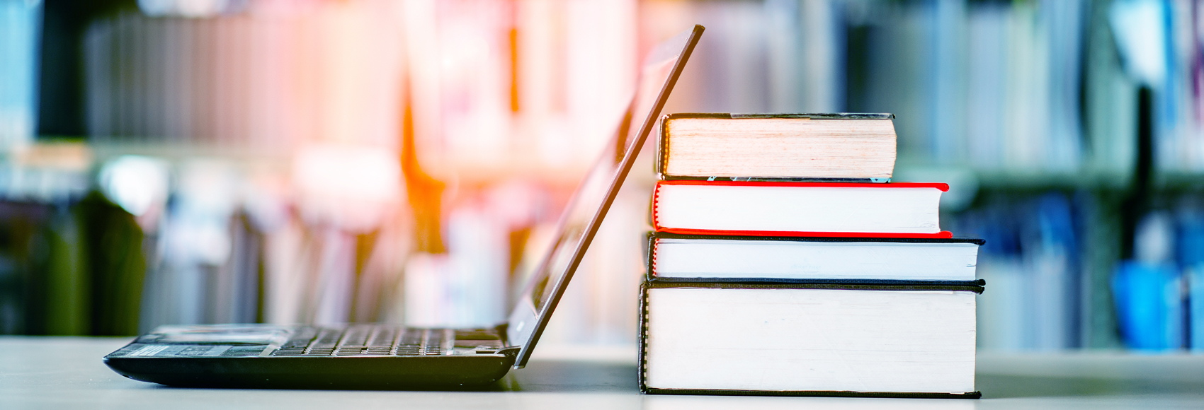 Bookshelves and laptops are placed on the library desk