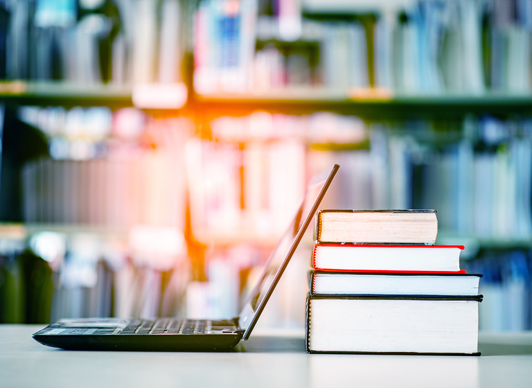 Bookshelves and laptops are placed on the library desk